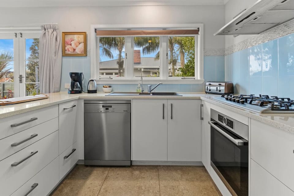 The kitchen is well-equipped with a coffee machine, dishwasher, microwave, gas cooktop, oven, and fridge/freezer.