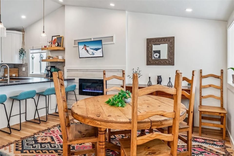 The dining space features a large table with comfortable seating for four, and additional high-top seating for three at the kitchen bar.