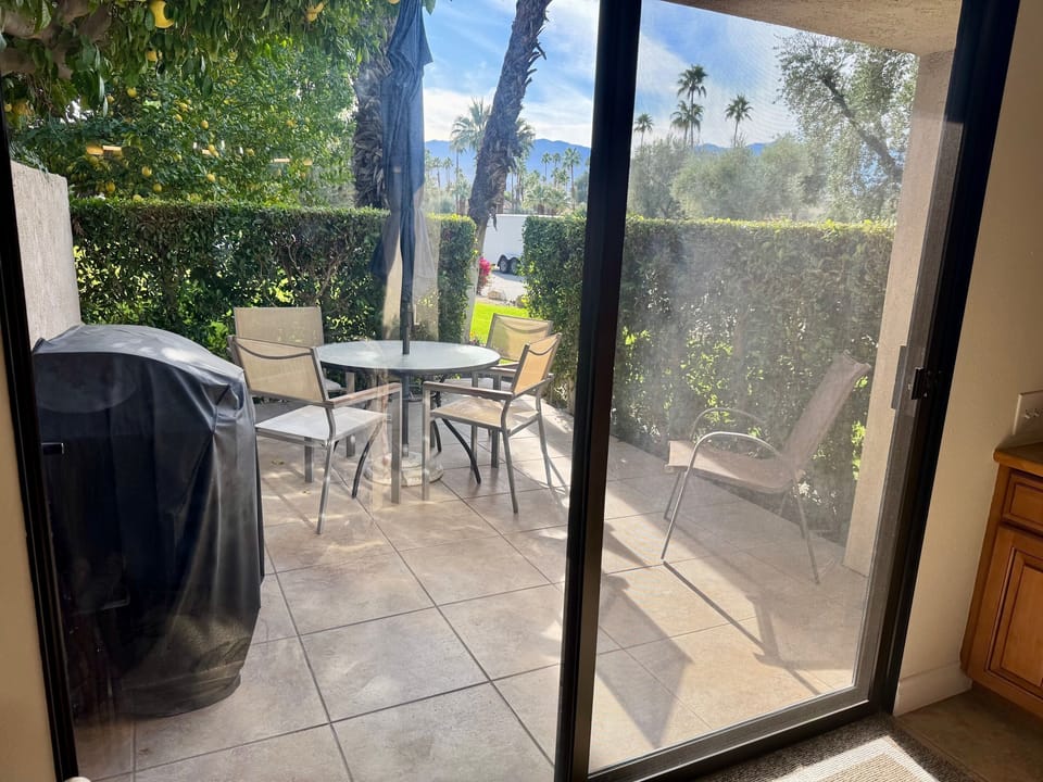 Patio with BBQ and dining with mountain view.