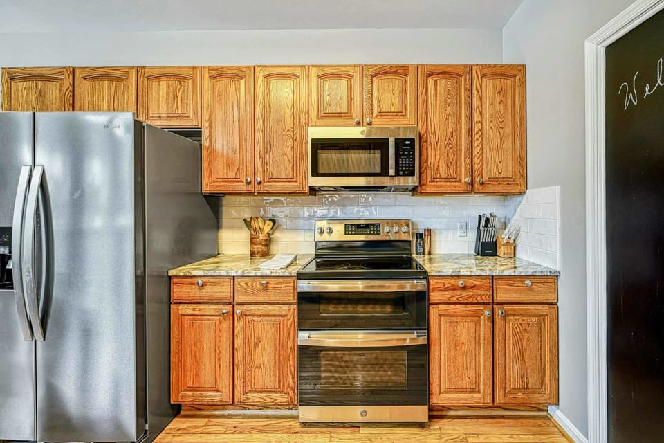 Kitchen - Oak cabinets with granite counters, stainless steel range, microwave, and subway tile backsplash.