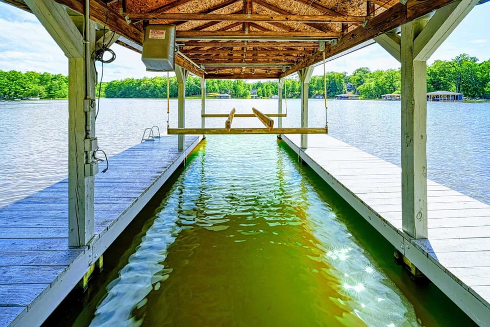 Dock - Covered boat lift with walkways and open water views from the private dock.
