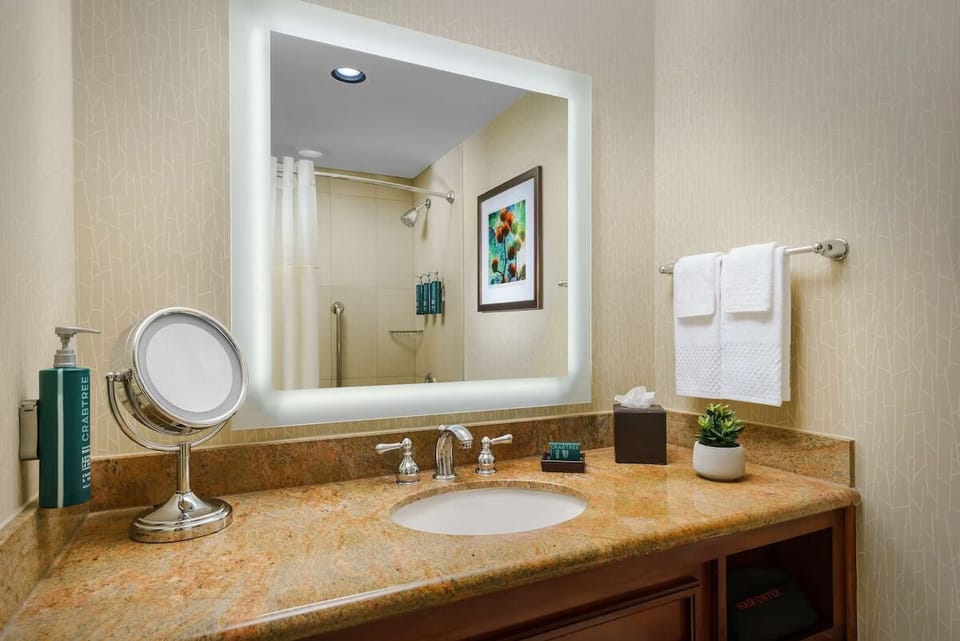 Refresh effortlessly at the glowing vanity with plush towels.