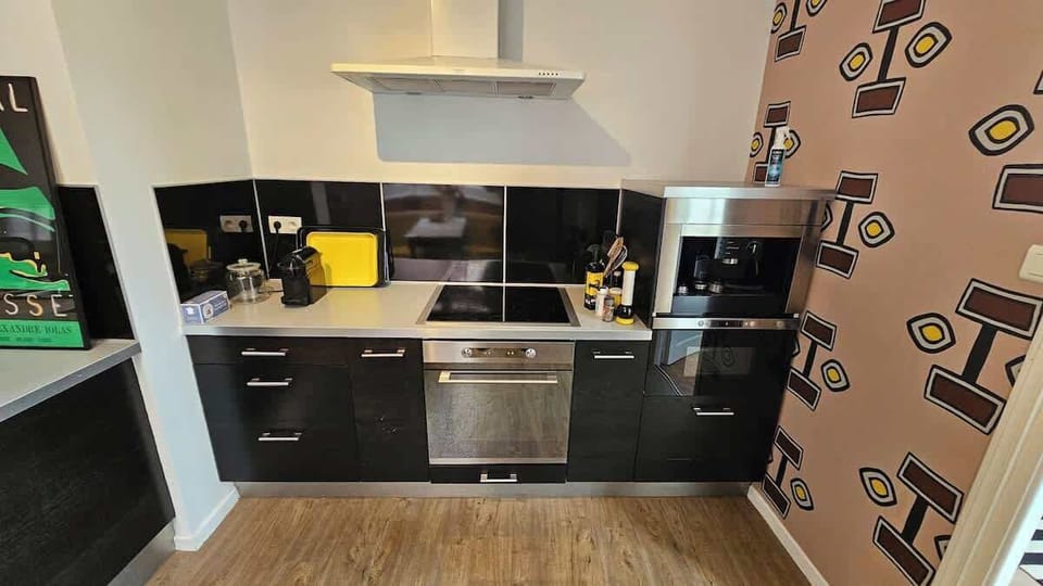 Cuisine équipée avec machine à café, bouilloire, grille-pain, micro-ondes, plaques de cuisson, four, lave vaisselle et réfrigérateur avec congélateur.
Coin repas pour trois personnes.