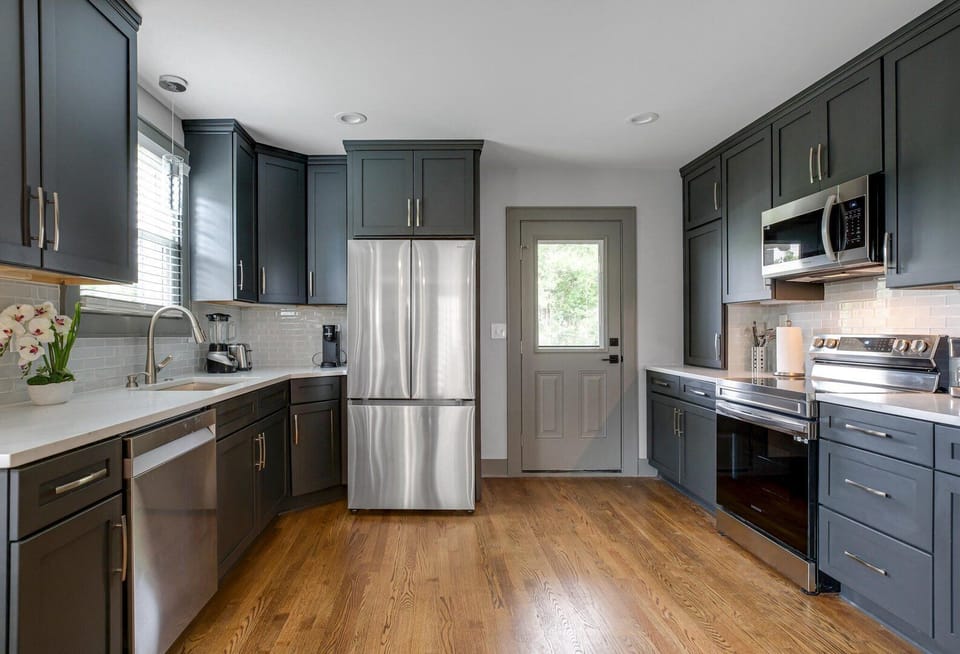 Fully equipped kitchen featuring stainless steel appliances and open counter space.