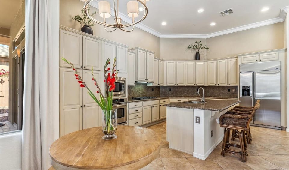 Kitchen Island, Table (with chairs), Stainless Steel appliances, gas stove. 