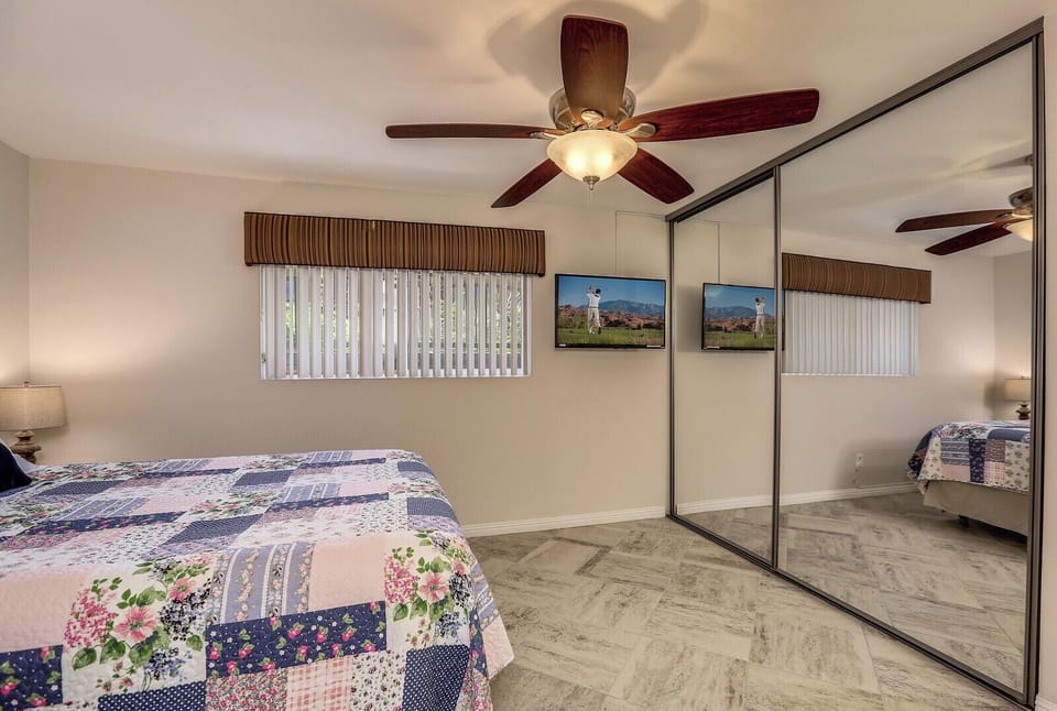 Primary bedroom with mirrored closets and natural light