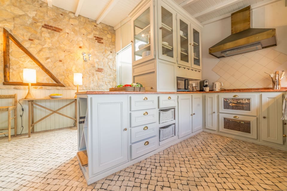 Spacious kitchen with white cabinetry and terracotta flooring — Villa Alegria, holiday villa in Sesimbra