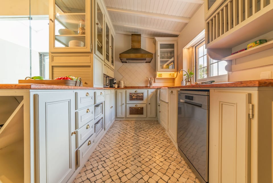 Spacious kitchen with cream cabinetry and terracotta flooring — Villa Alegria, luxury holiday villa in Sesimbra