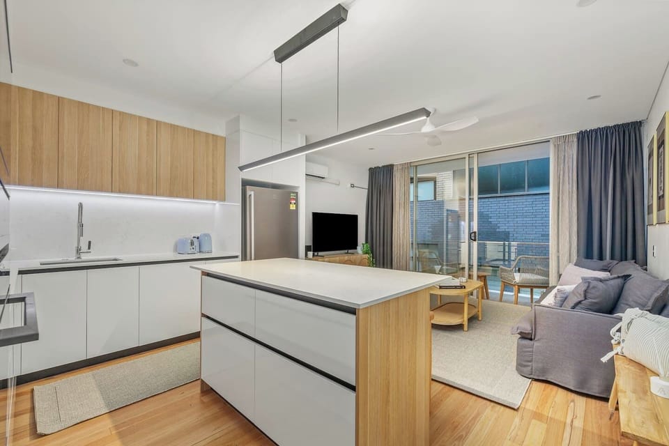 Enjoy seamless open-plan living where the sleek kitchen flows into a comfortable lounge and out to a peaceful balcony, offering a harmonious blend of functionality and calm.