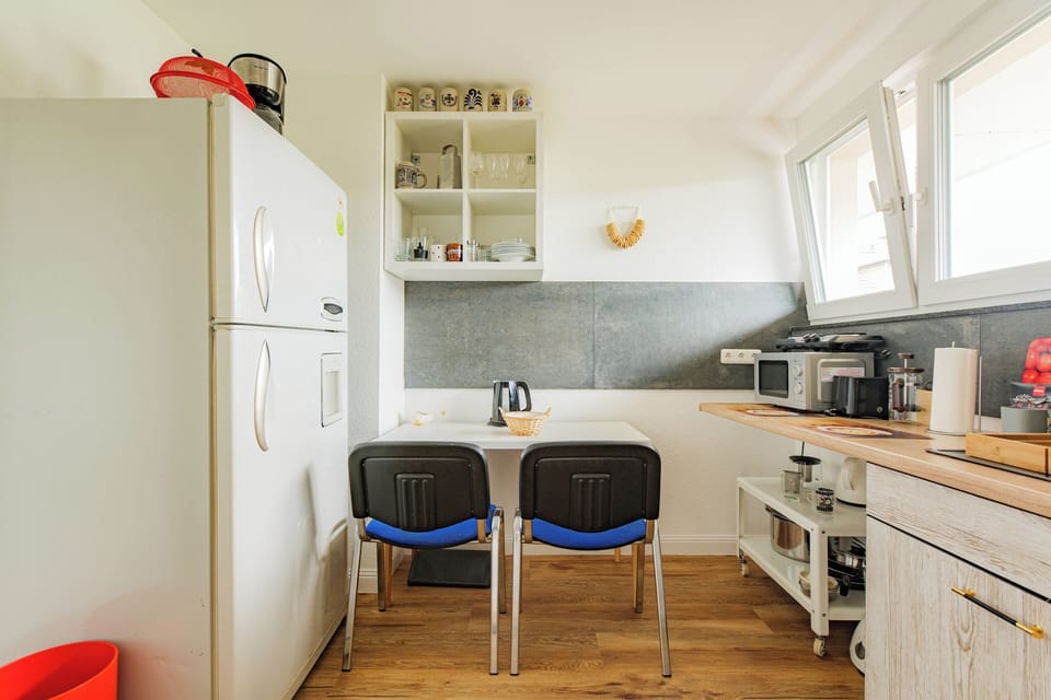 Essbereich mit Kühlschrank, Tisch und allem nötigen Geschirr.