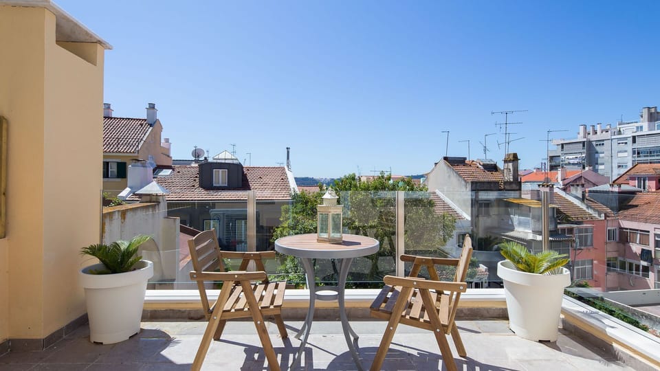 Enjoy the tranquil charm of Lisbon from this serene terrace, offering views over the city’s rooftops. Perfect for unwinding with a cup of coffee or a good book under a clear sky. #LisbonViews #CityTerrace #OutdoorLiving"