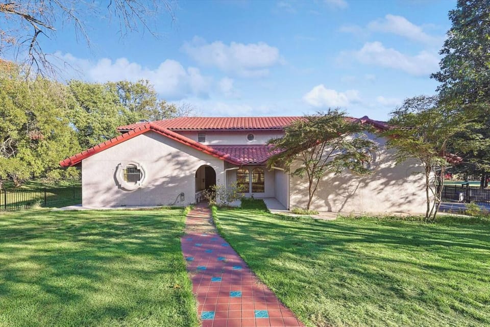 The exterior view of this elegant stucco home with a tiled roof.