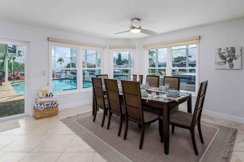 Gather around your elegant dining table for eight, where floor-to-ceiling windows frame tropical views and the sparkling pool beckons just steps away.