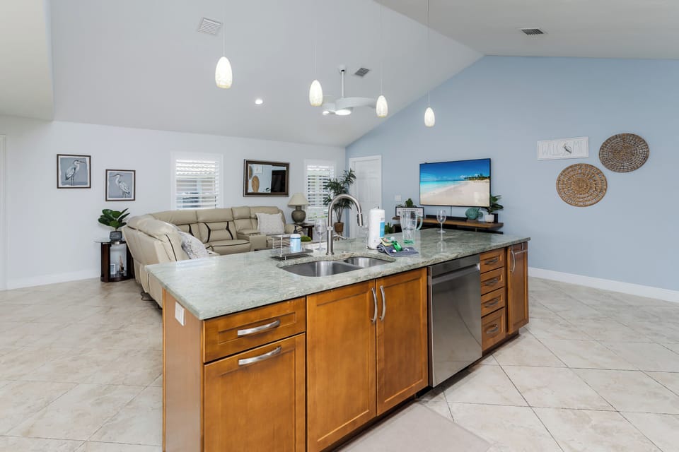 Prepare meals in your spacious modern kitchen featuring granite countertops, warm wood cabinetry, and stainless appliances.