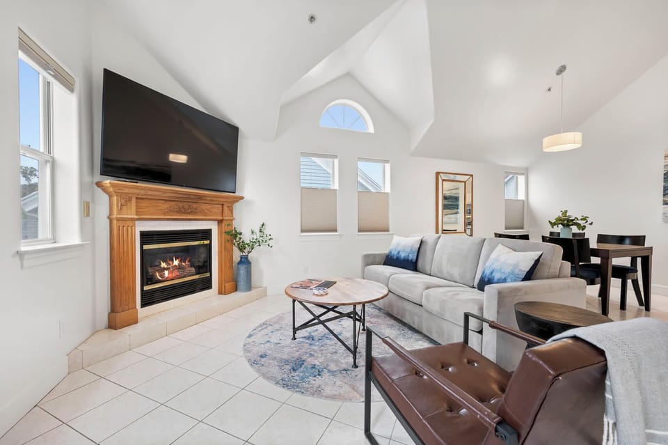 Cozy lounge with sofa, TV, and inviting fireplace for relaxing moments