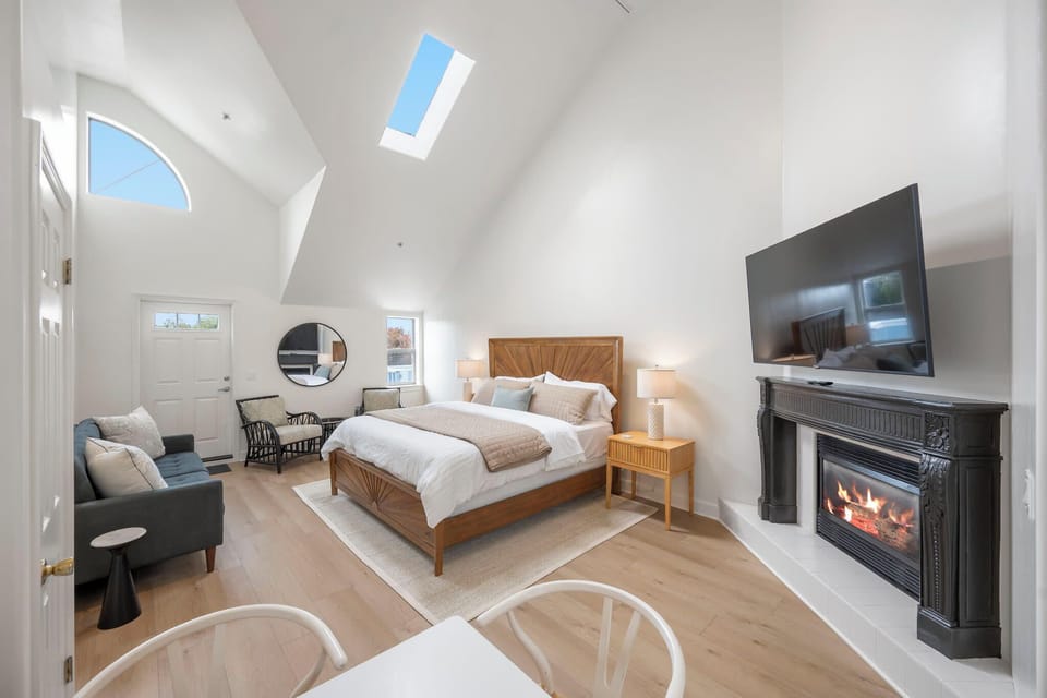 Inviting king bedroom featuring a sofa bed, TV, and cozy fireplace