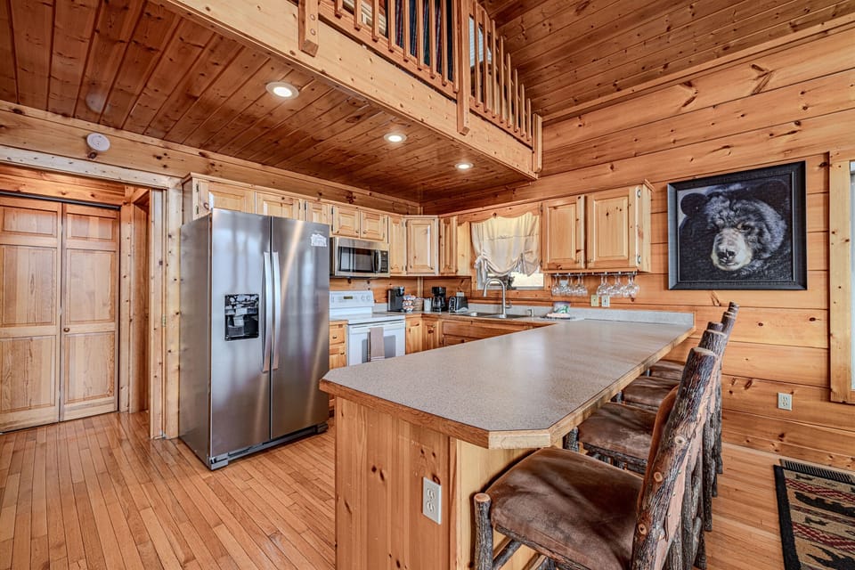 Cook, gather, and enjoy! This kitchen features the rustic warmth of natural wood cabinetry and floors, perfectly balanced with modern stainless steel appliances.