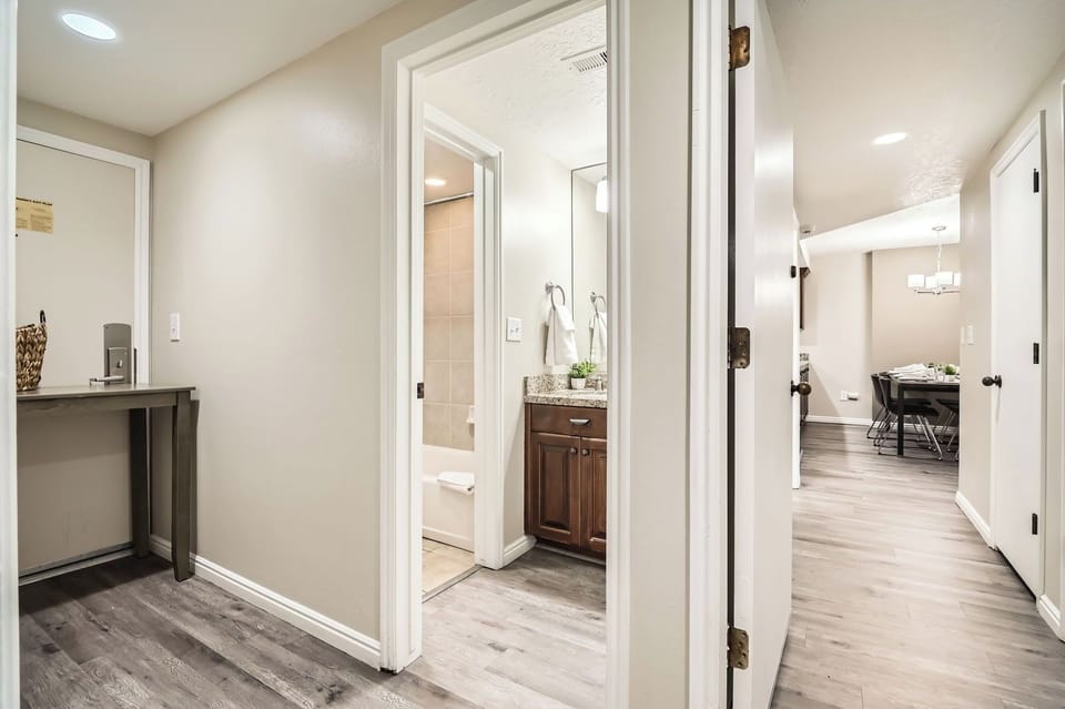 Modern & clean hallway bathroom featuring a sleek vanity and tub/shower combo. A bright, refreshing space to unwind during your stay.