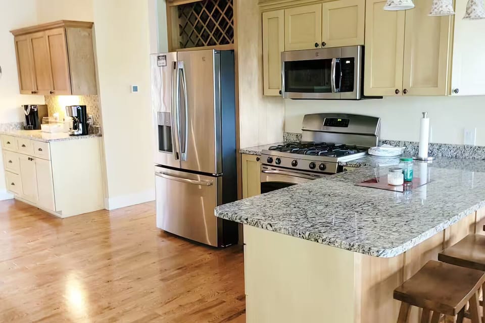Main house kitchen with gas stove and breakfast bar.