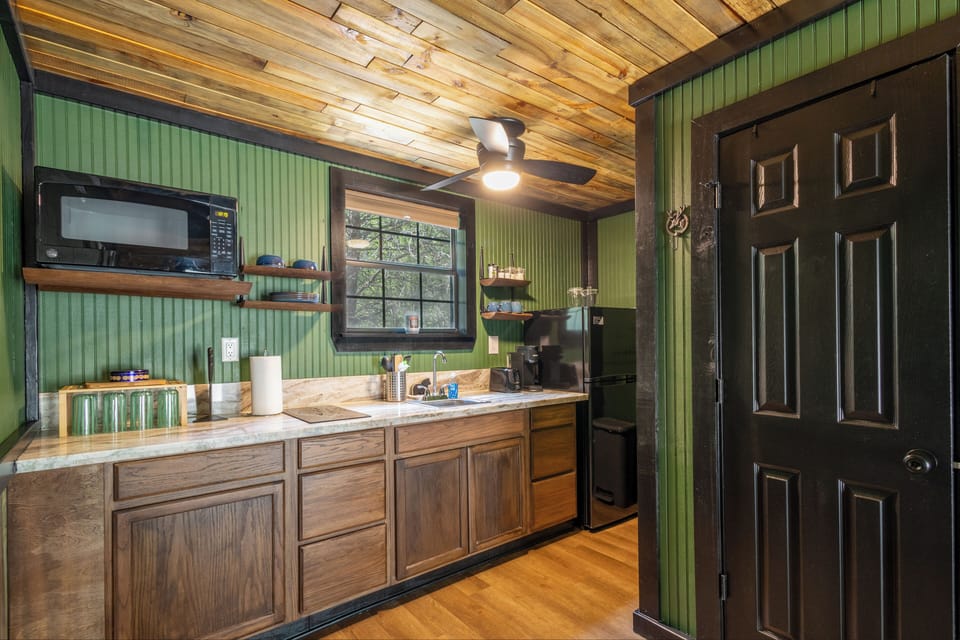 Kitchen has marble counters, 2 burner stove, microwave, fridge, toaster, Keurig and Ninja blender with your basic kitchen essentials.