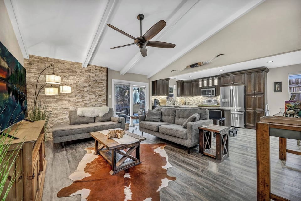 Upon entering, you will be warmly greeted by the open floor plan connecting the living room and the fully remodeled kitchen. Relax on the comfortable couch or chaise in the living room, featuring a 65-inch TV and art from local Austin artists.