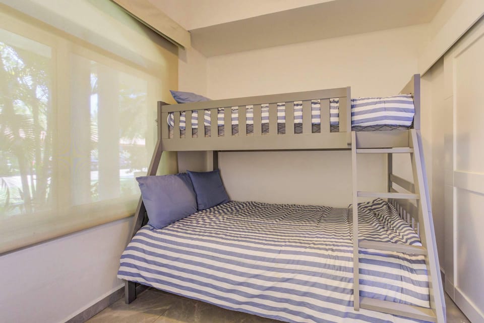 Room with double bed and bunk bed with single bed. It has a private bathroom