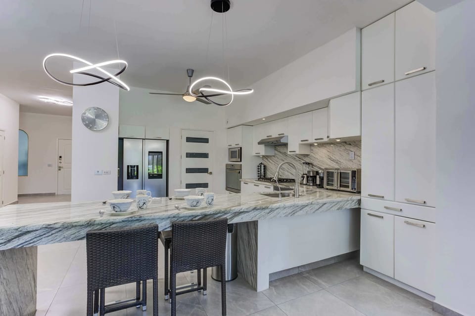 Full kitchen with breakfast area, with stove, refrigerator and cooking elements for your stay.