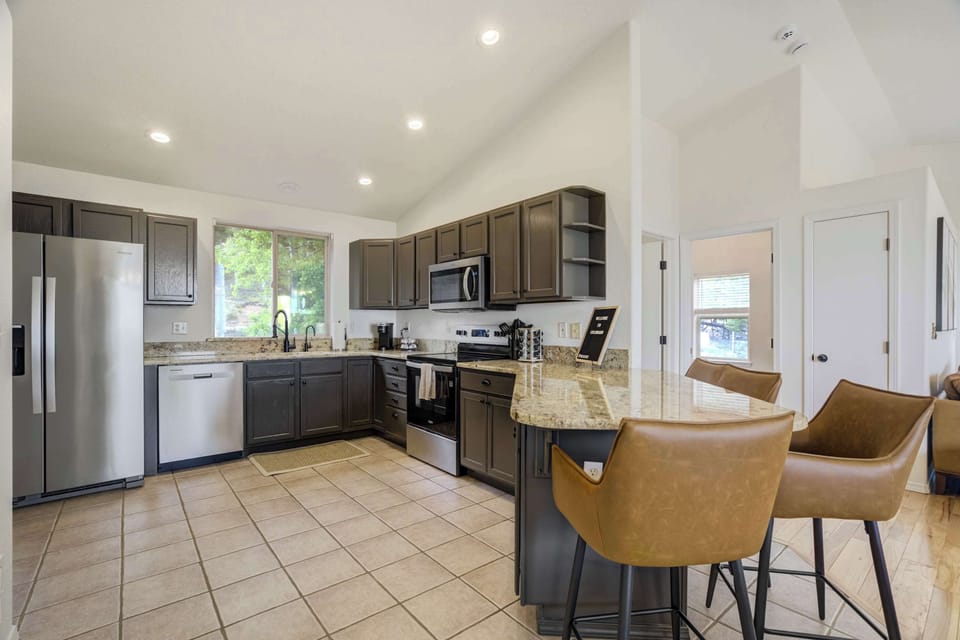 The modern kitchen includes stainless steel appliances, ample counter space, bar seating, and all the essentials for cooking and gathering with ease.

