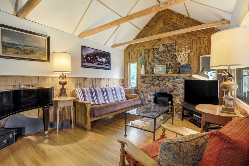 Eclectic and inviting, this mountain living room features exposed beams, a vintage piano, and a small stove framed by a stone surround—blending rustic charm with artistic touches for the perfect place to unwind.















