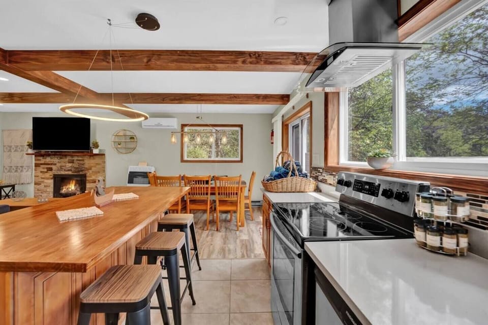 Modern kitchen with a central island and bar seating, adjacent to a spacious dining table.