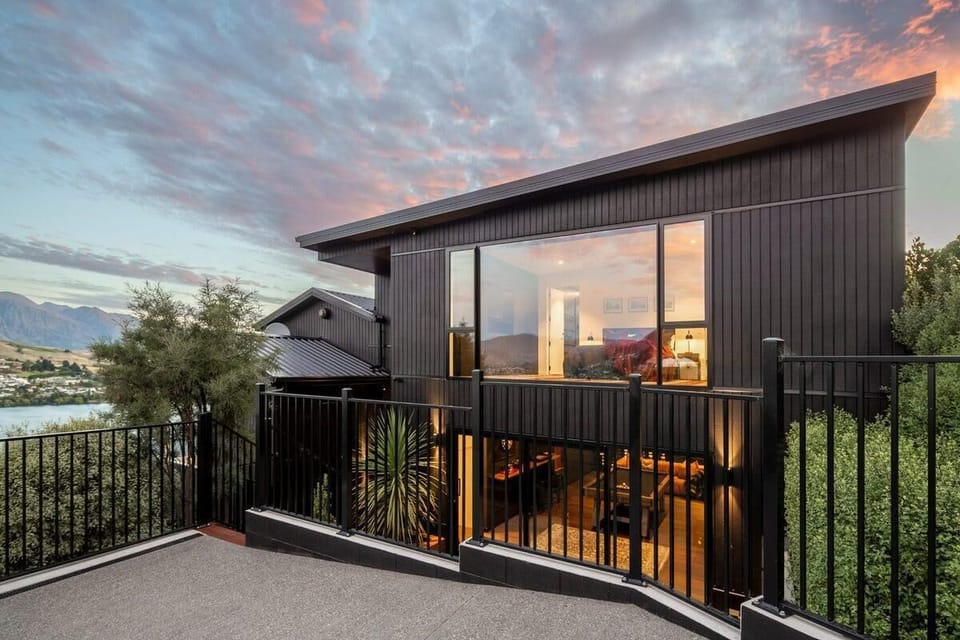 Stylish modern home with large windows and sunset views.
