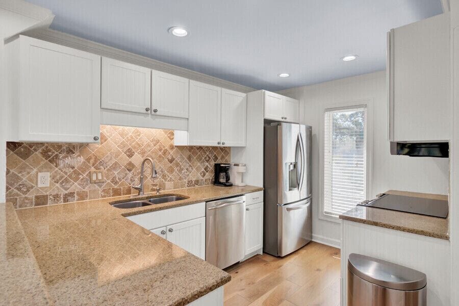 You'll love creating meals in this pristine kitchen featuring granite countertops, stylish tiled backsplash, and modern stainless-steel appliances ready for your culinary adventures.