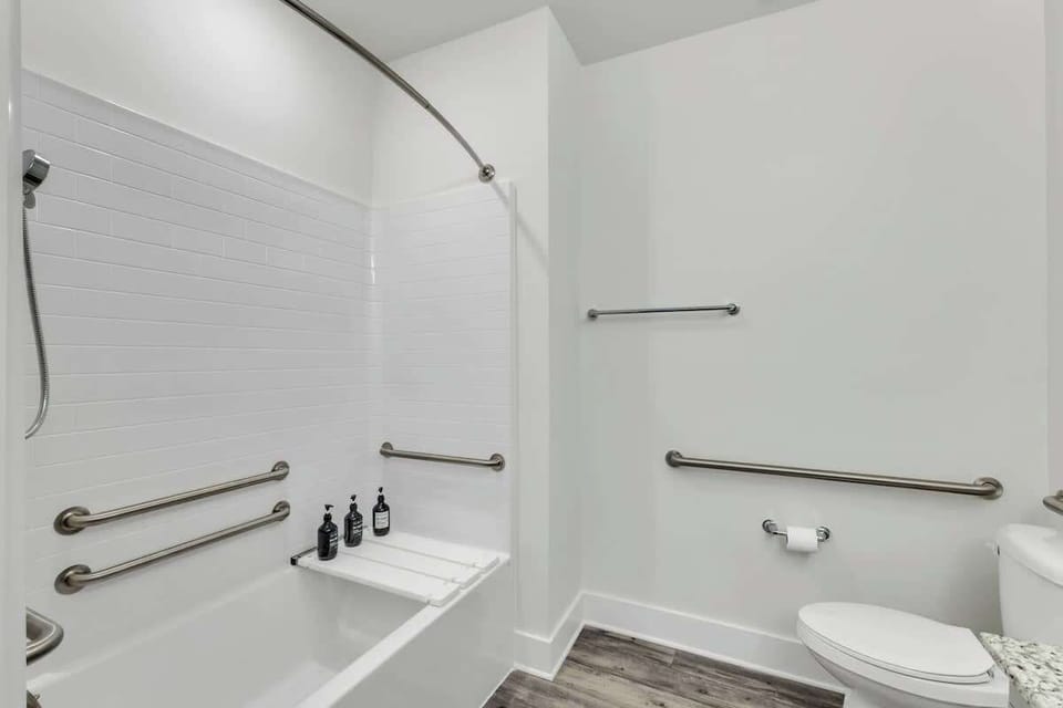 A bright and modern bathroom featuring a sleek vanity, a spacious bathtub with a shower, and elegant finishes. Clean and well-appointed, offering a comfortable and stylish space for your stay.