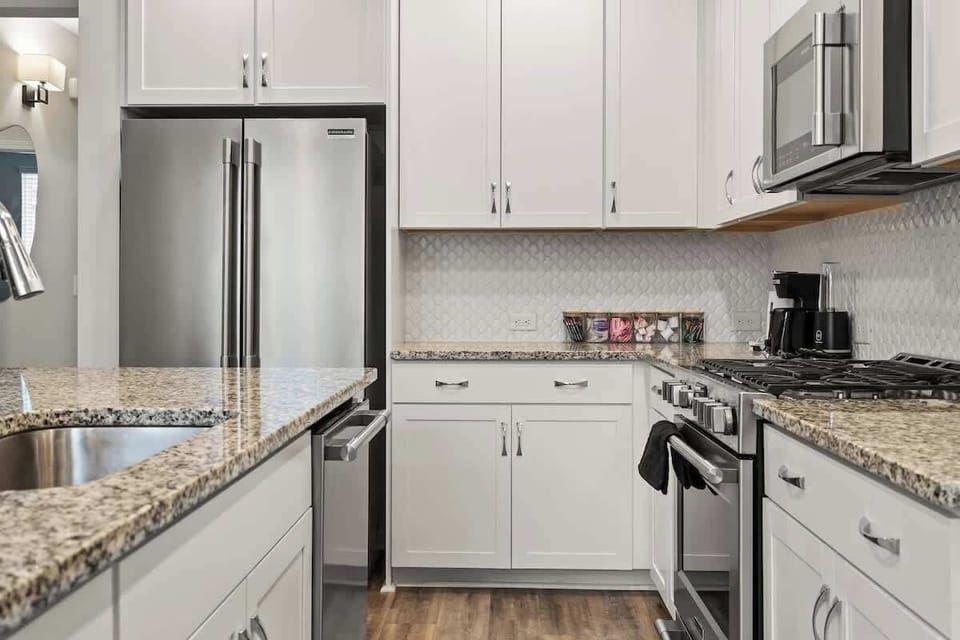 Whip up a meal in this stylish kitchen, featuring a spacious granite island, stainless steel appliances, and plenty of cabinet space. The open layout flows into the living area, making it perfect for cooking and hanging out.