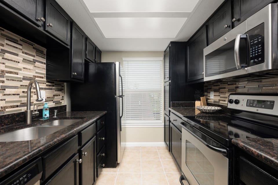 Modern kitchen w fully stocked appliances and kitchenware for cooking
