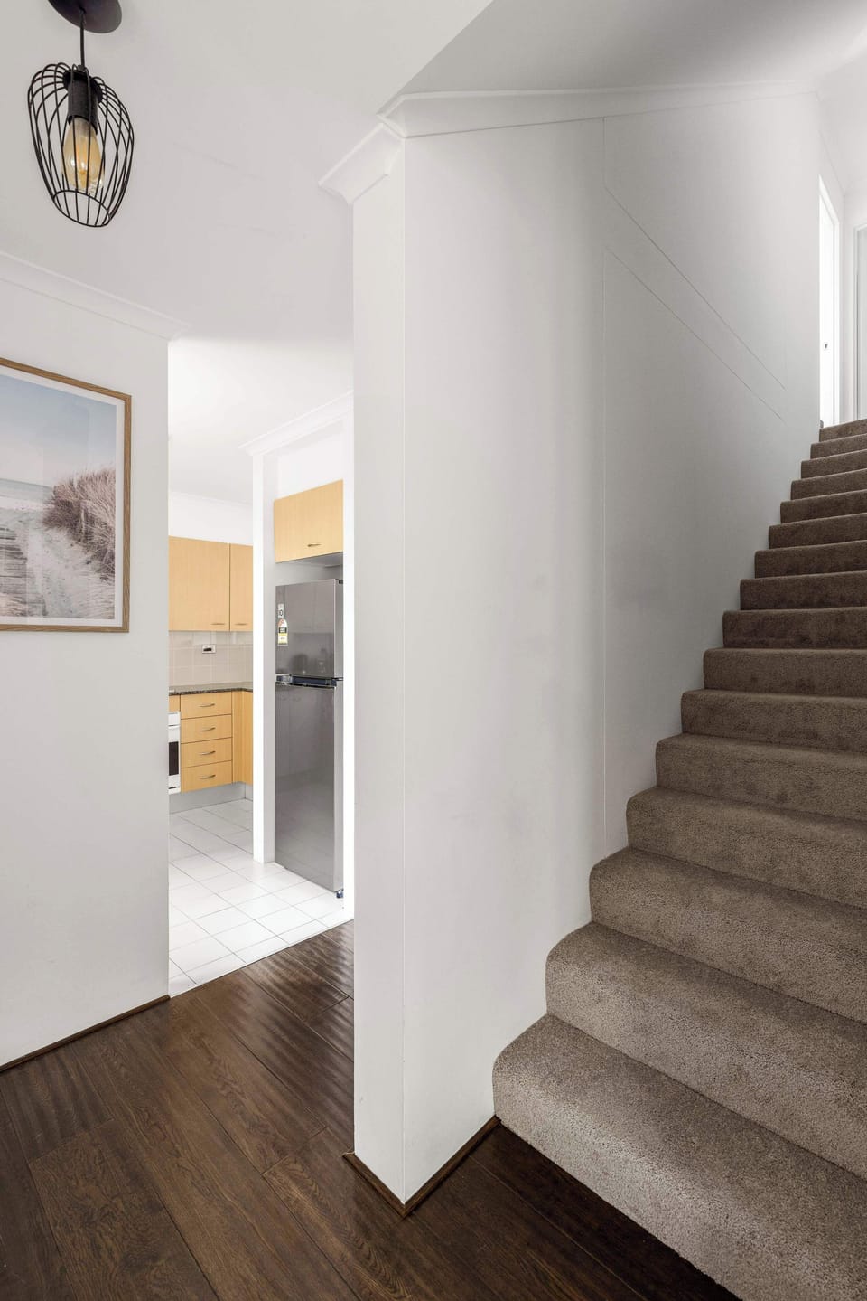 Modern Entryway with Open Staircase to the Ensuite Master Rooms, A bright and welcoming entrance featuring a stylish staircase and sleek wooden floors.
