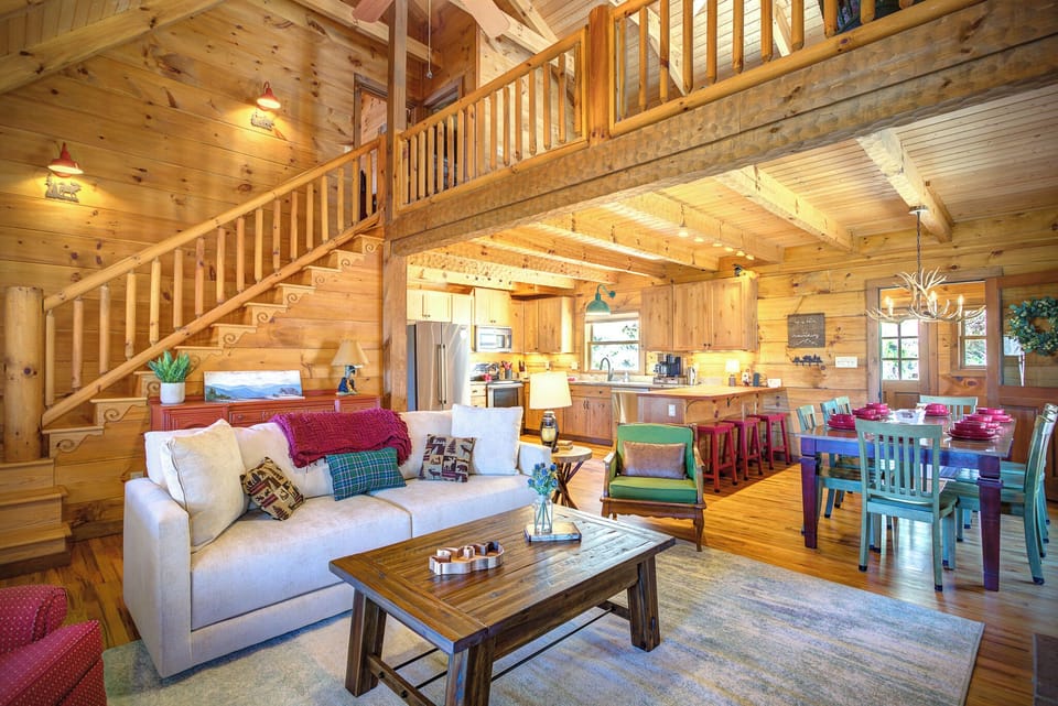 Great room with vaulted ceilings open to loft above. True log cabin.