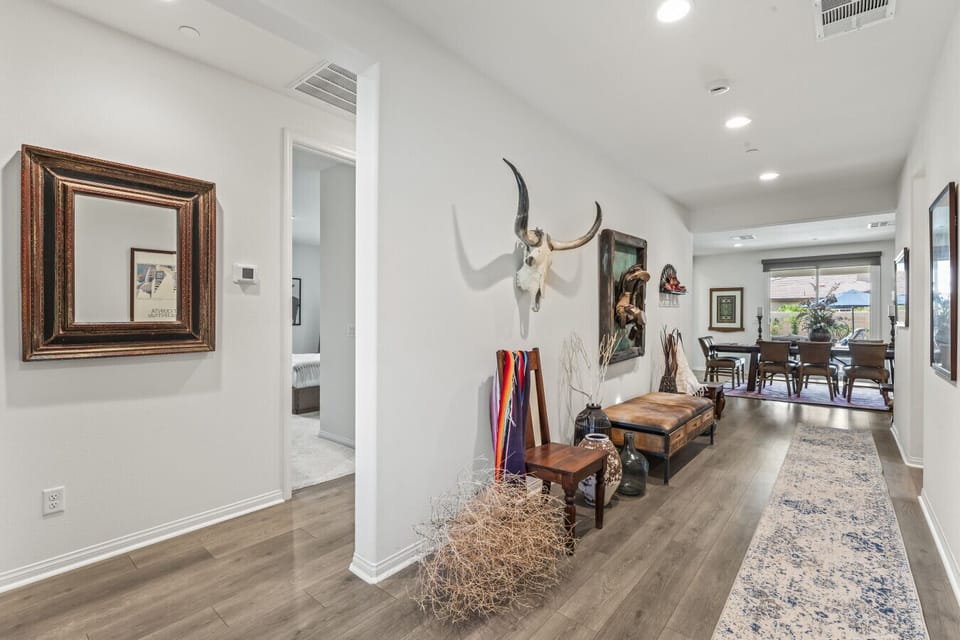 Welcoming entry hallway w/ bench seating, wall decor & views into the living space