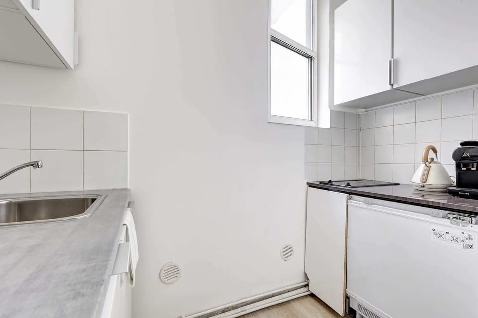 Cuisine composée d'une bouilloire, d'une cafetière, d'un micro-onde et d'une plaque de cuisson