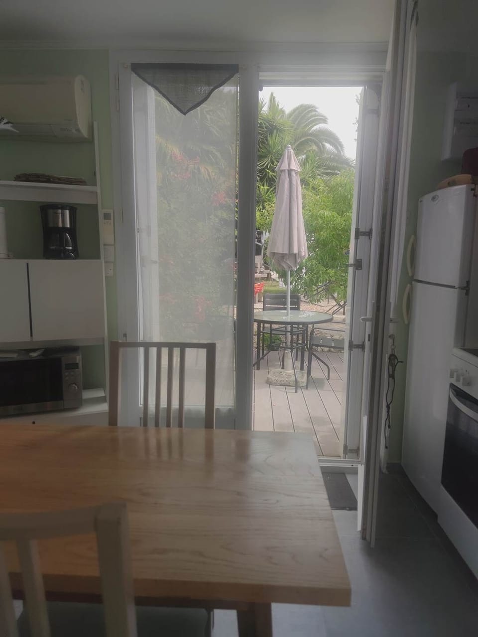 Table avec vue sur la terrasse Une transition naturelle entre l’intérieur et l’extérieur pour savourer chaque instant dans un cadre serein.