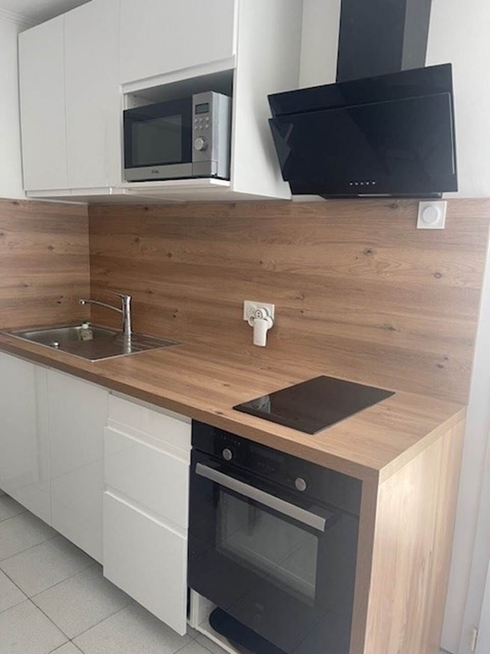 Maison Réthaise 2 – Cuisine pratique et design Un espace clair et parfaitement équipé : four, plaque, lave-vaisselle, micro-ondes. Le confort du quotidien à deux pas du marché médiéval.