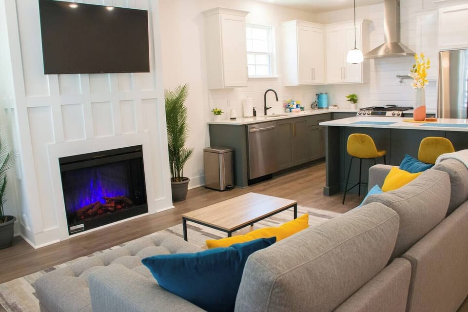 Relax in our stylish living room with a cozy fireplace and smart TV, seamlessly connected to a modern, fully-equipped kitchen perfect for all your culinary needs.