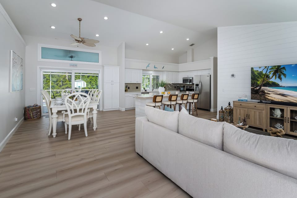Step into your bright, open-concept haven where coastal elegance meets modern comfort. Relax on the plush sectional while natural light floods through expansive windows, creating the perfect atmosphere for memorable meals and lazy afternoons.