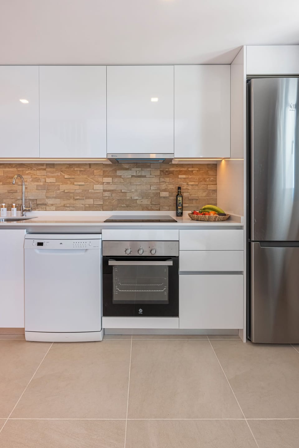 The open kitchen is equipped with an oven, microwave, fridge, and all necessary utensils. (1)