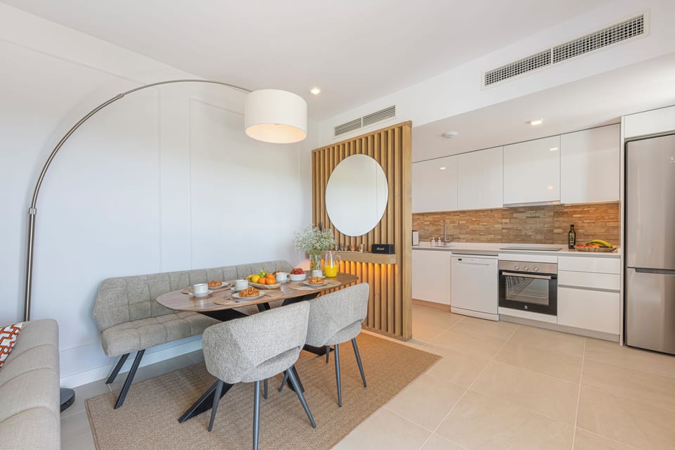 The living-dining room has a spacious sofa, table for 4, Smart TV, and balcony access. (10)