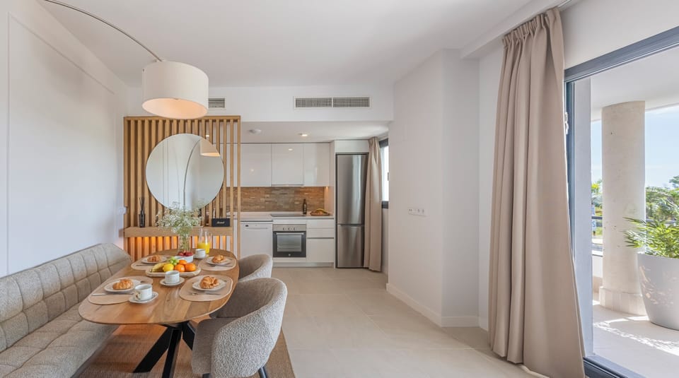 The living-dining room has a spacious sofa, table for 4, Smart TV, and balcony access. (9)