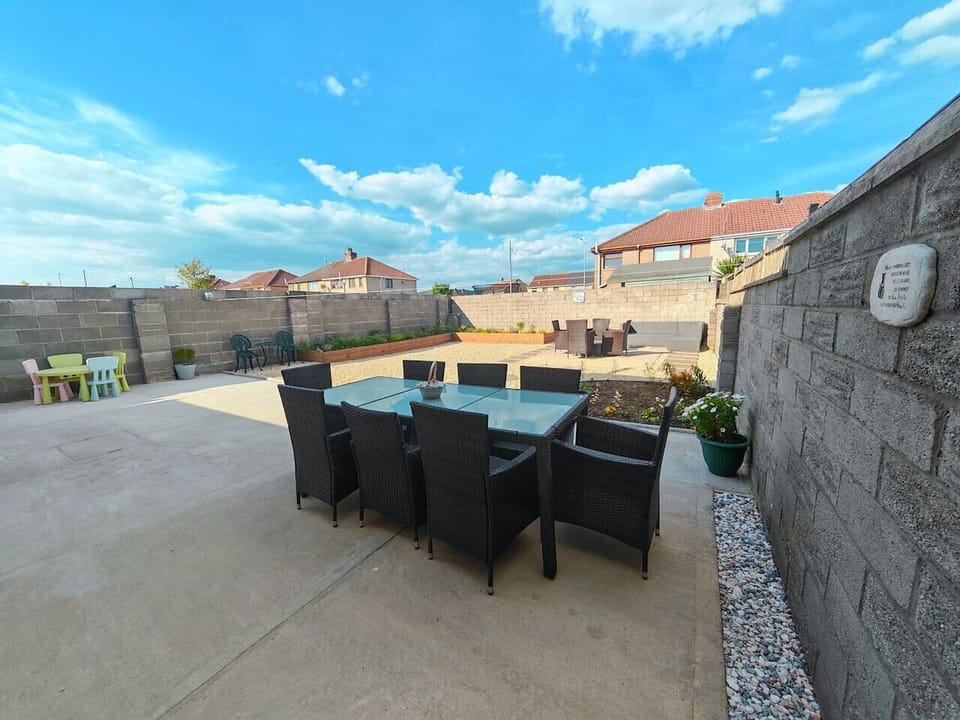 Sunny rear garden with raised beds and stepping-stone path.