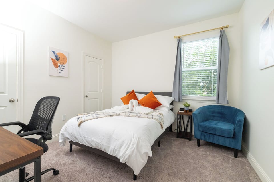 Bedroom 3 has queen bed, desk/chair and comfy accent chair in the corner.