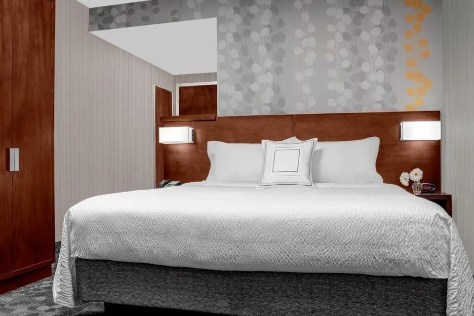 Drift off in a plush king bed under soft lighting.