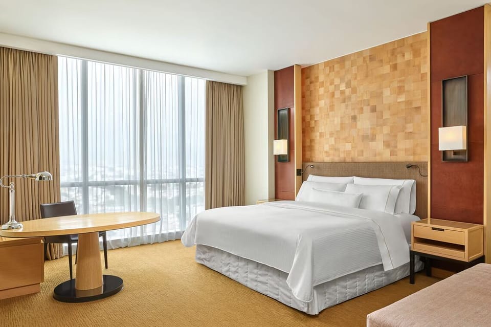 Unwind in a serene king bed beneath warm designer walls.